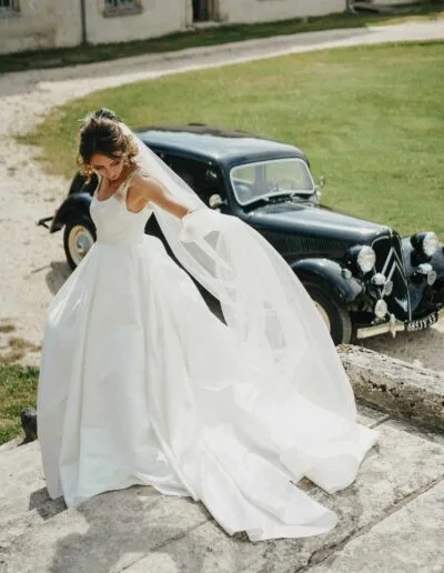 Robe princesse en satin duchesse avec dentelle dorée incrustée sur les épaules, élégante et raffinée.